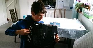 Teenager playing the accordion in online lesson
