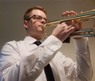 A young man learning to play the cornet in online lessons with Your Space Music Lessons