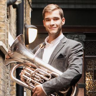 online brass teacher Chris Robertson who teaches with Your Space Music Lessons. He is holding an euphonium in the photo.
