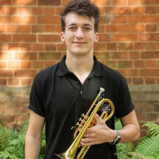 Online brass teacher Tom Smith holding a cornet. Tom teaches with Your Space Music Lessons